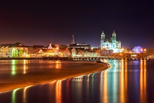 View of Athlone town and church at night with lights on the water
