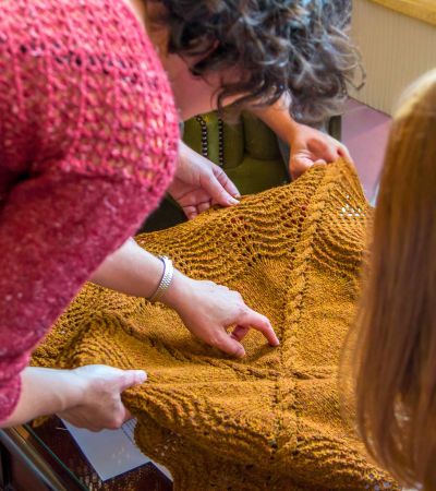 Women examining piece of knitwear