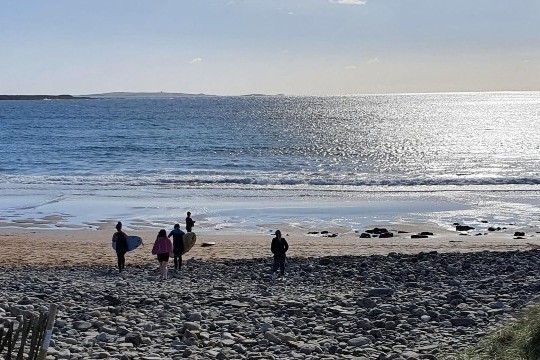 Beach with surfers heading to water